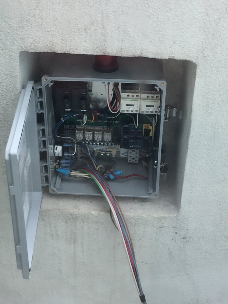 Open septic pump control and alarm panel in a stucco wall